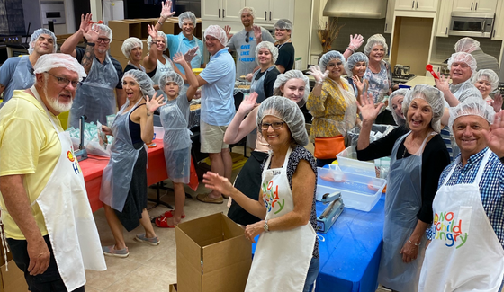 volunteers packing lunches for no child hungry